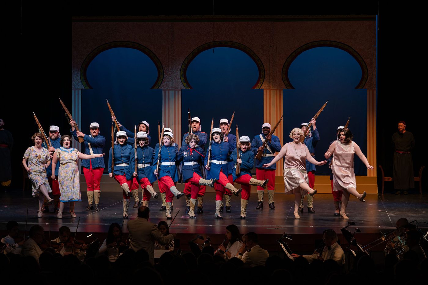 Legionnaires and the company in a dance line across the terrace