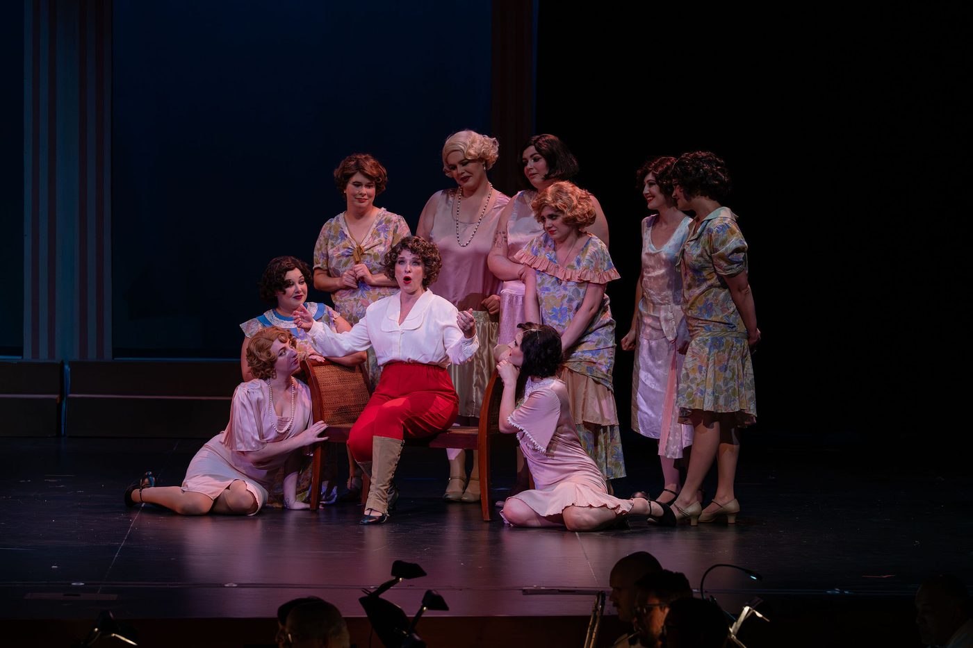 Seated at center, surrounded by the women of the company